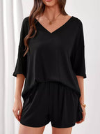 Women's casual V-neck top and shorts set in solid color, trendy two-piece outfit by Trendsi, perfect for relaxed, stylish looks.