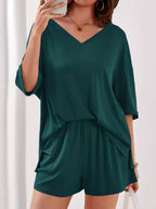 Women's casual V-neck top and shorts set in solid color, trendy two-piece outfit by Trendsi, perfect for everyday wear.