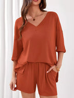 Women's casual V-neck top and shorts set by Trendsi, solid color two-piece outfit perfect for relaxed everyday wear.