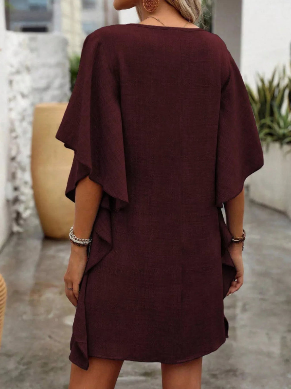 Women's flowy V-neck casual mini dress with ruffled sleeves, by Trendsi, featuring a relaxed fit and feminine design.
