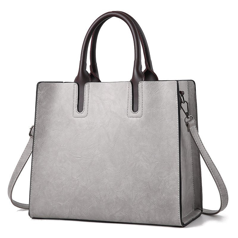 Leather women's handbag by Plush Fashion Hub with gold hardware and adjustable strap, stylish and versatile accessory.