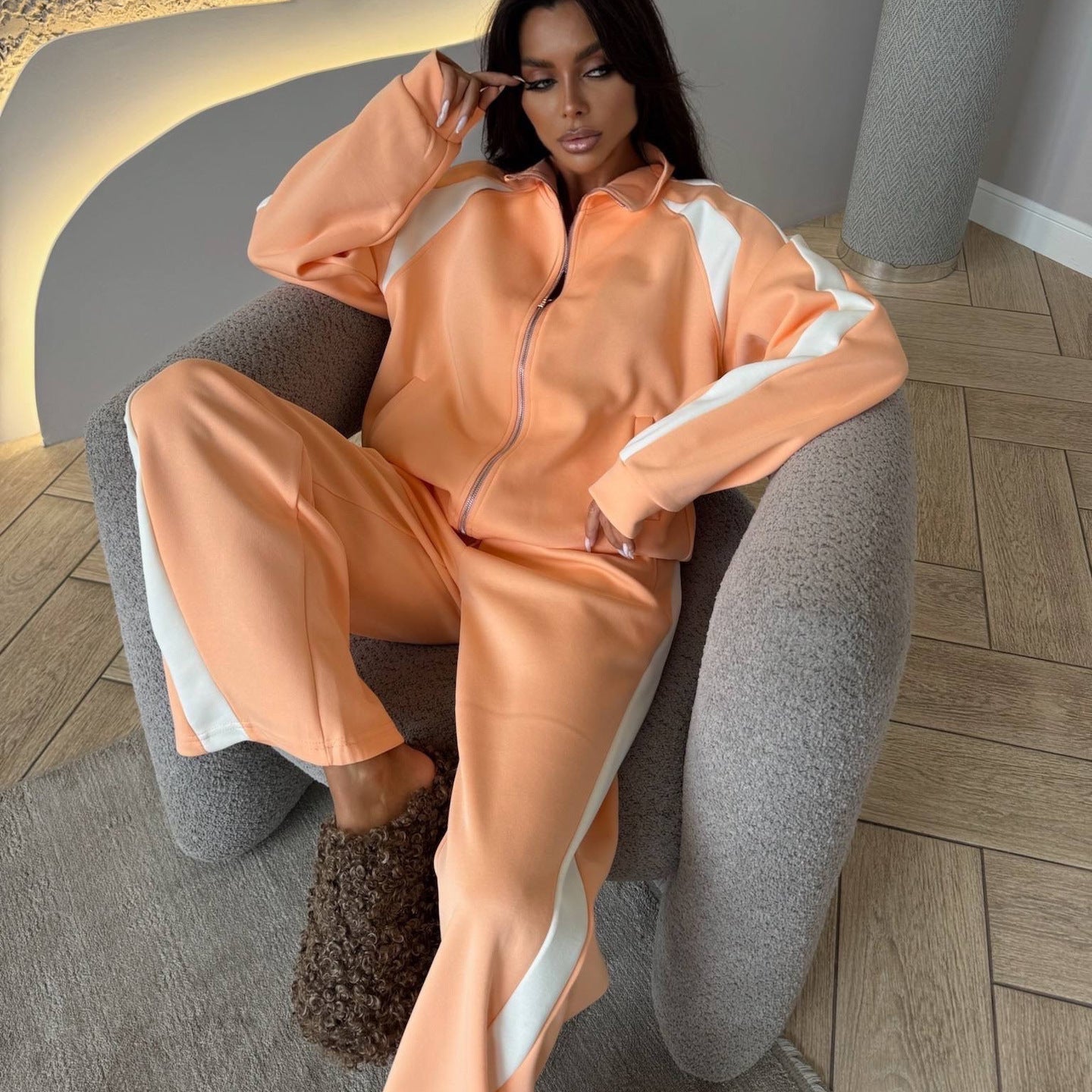 Women’s long-sleeve zip-up jacket and sweatpants two-piece set by Plush Fashion Hub, shown on a model in casual indoor setting.