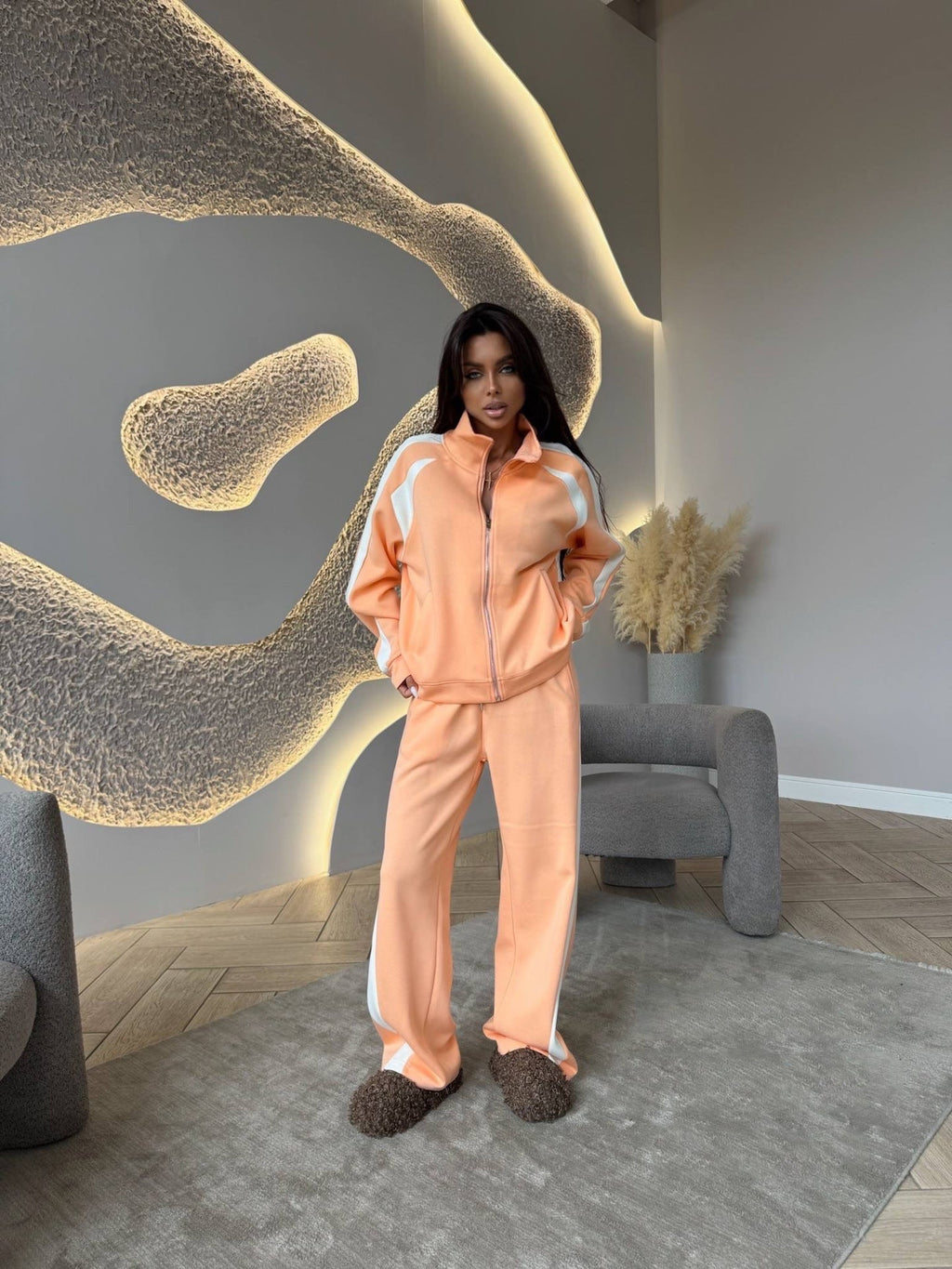Women’s long-sleeve zip-up jacket and sweatpants two-piece set by Plush Fashion Hub, shown on a model with a casual indoor background.
