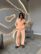 Women’s long-sleeve zip-up jacket and sweatpants two-piece set by Plush Fashion Hub, shown on a model with a casual indoor background.