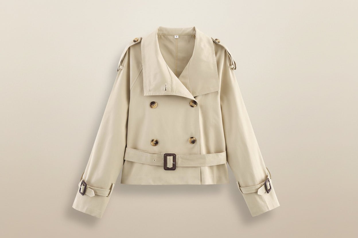 Women's short trench coat with notch collar and belt buckle detail, stylish jacket by Plush Fashion Hub.