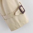 Women’s short trench coat with notch collar and belt buckle detail, stylish jacket from Plush Fashion Hub.