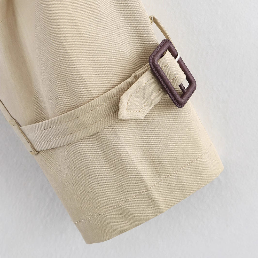Women’s short trench coat with notch collar and belt buckle detail, stylish jacket from Plush Fashion Hub.