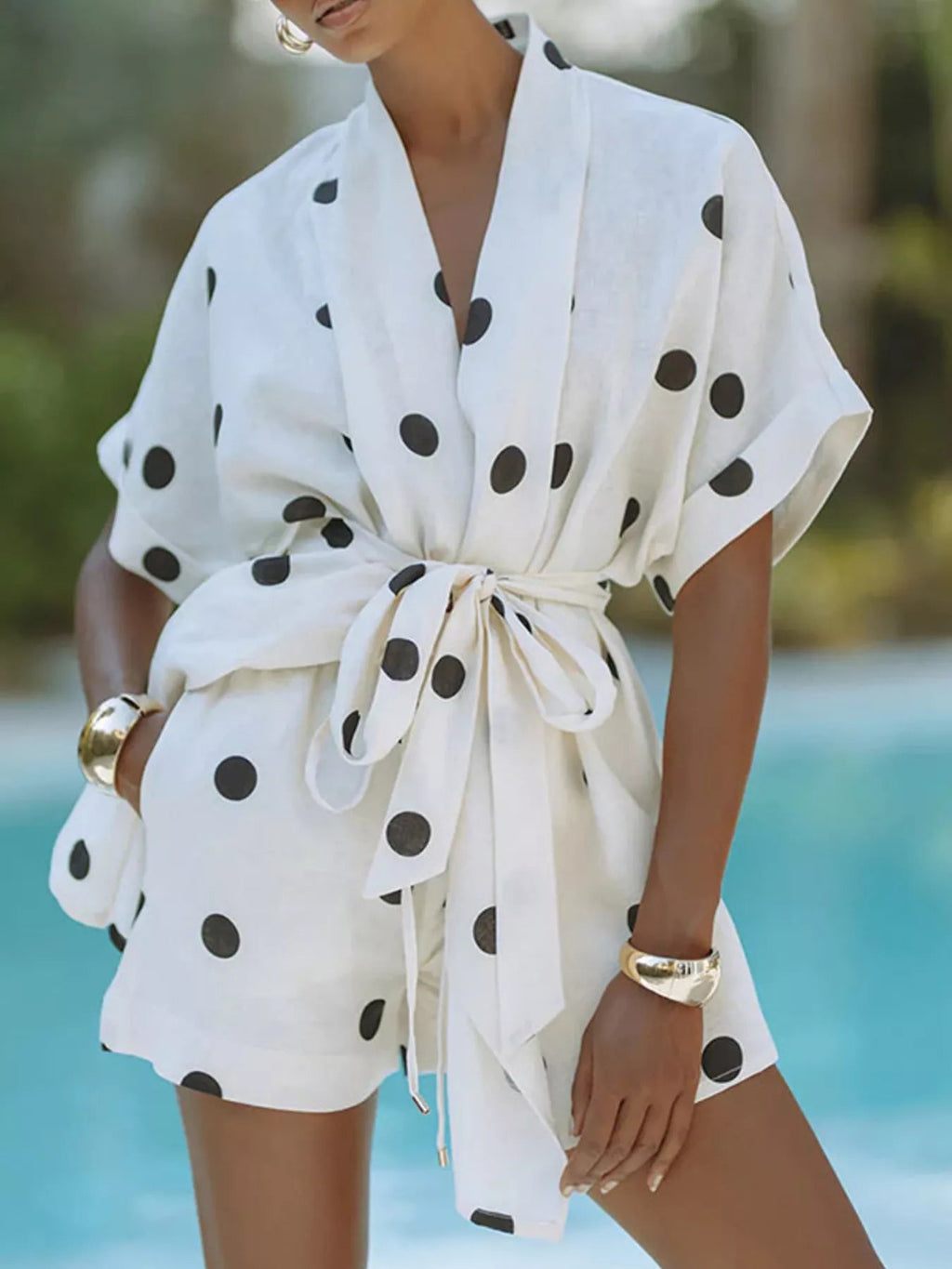 Women's polka dot tie waist top and shorts set by Trendsi, casual two-piece outfit with a relaxed fit and playful pattern.