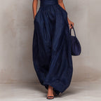Women's sleeveless striped wide-leg jumpsuit with pockets, casualwear by Plush Fashion Hub, shown hanging on a clothing rack.